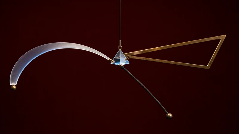 Dark kinetic sculpture with three distinct balancing inputs converging around one stabilizing glass prism.